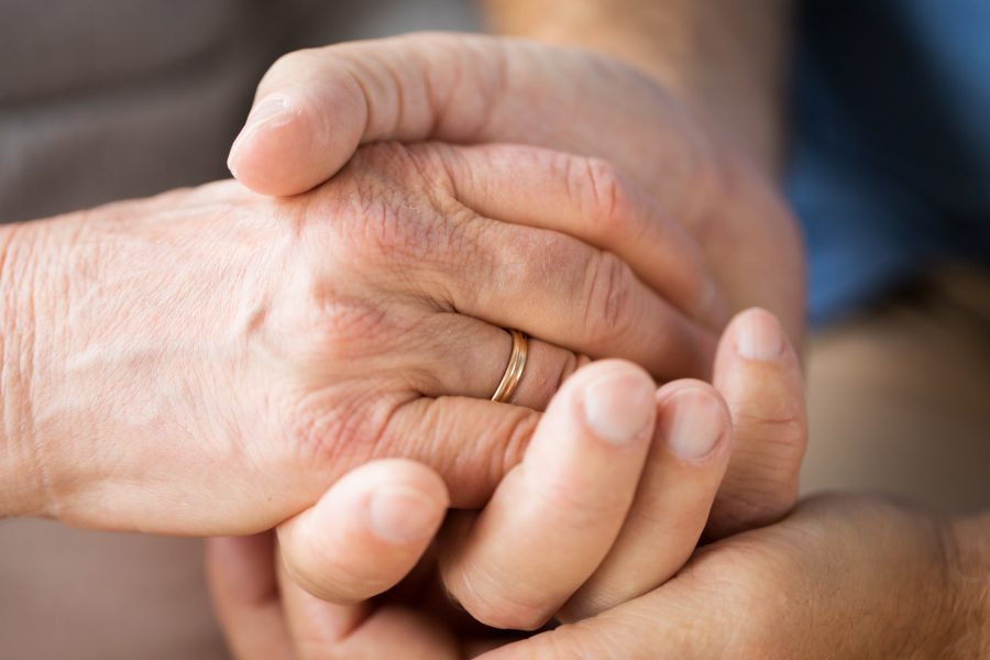 close up of senior couple holding hands